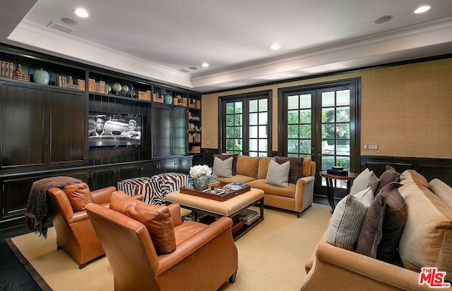 home theater featuring french doors, a tray ceiling, crown molding, and light carpet