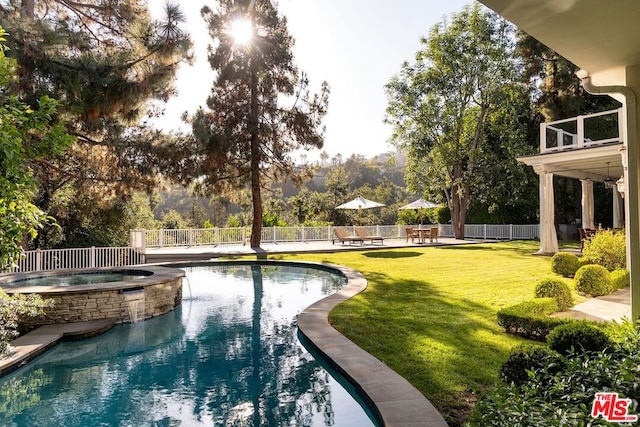 view of swimming pool with a lawn and an in ground hot tub