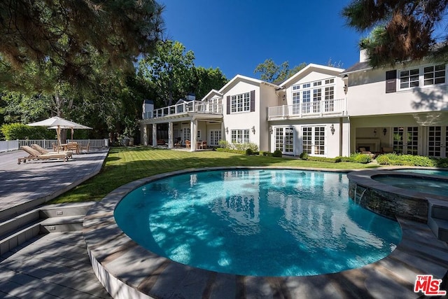 exterior space featuring an in ground hot tub and a yard