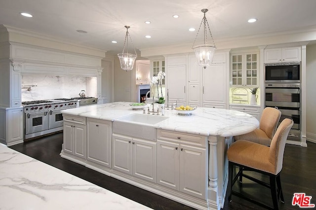 kitchen featuring an island with sink, appliances with stainless steel finishes, and white cabinetry