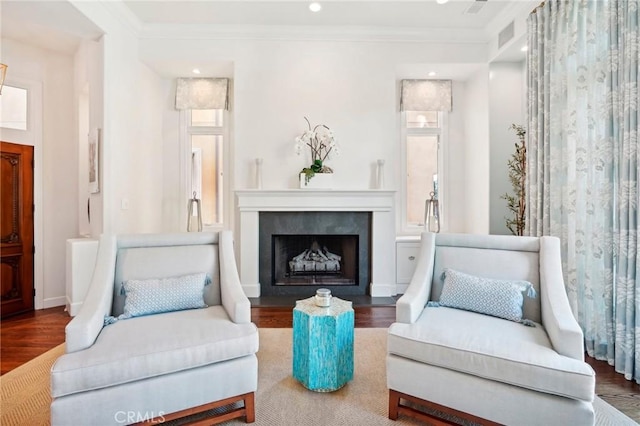 living area with wood-type flooring and ornamental molding