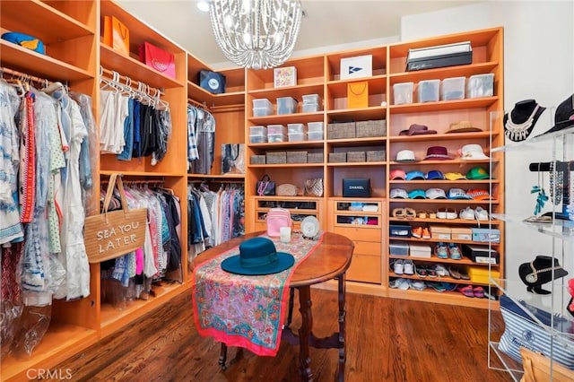 walk in closet with wood-type flooring and an inviting chandelier