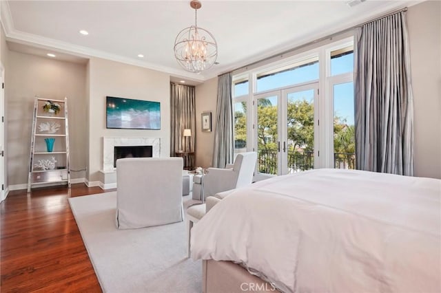 bedroom featuring access to outside, ornamental molding, a fireplace, a notable chandelier, and dark hardwood / wood-style flooring