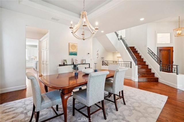 dining room featuring a tray ceiling, hardwood / wood-style floors, and a notable chandelier