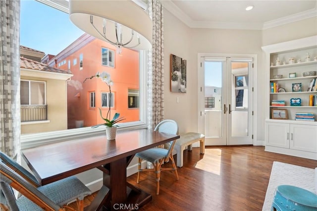 dining room featuring hardwood / wood-style flooring, a notable chandelier, and crown molding