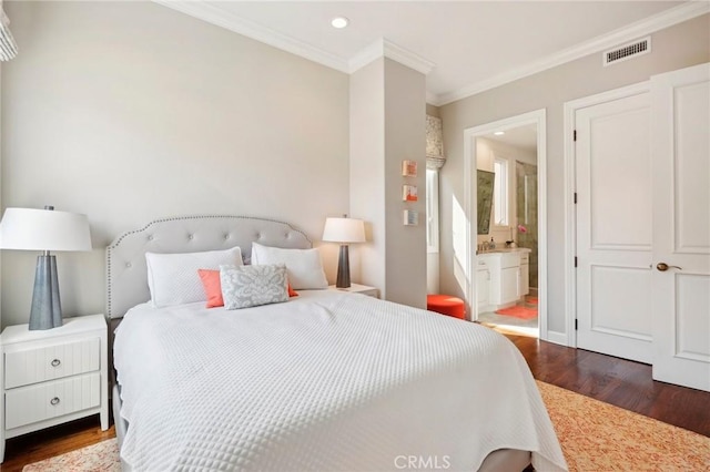 bedroom featuring ensuite bath, dark wood-type flooring, and ornamental molding