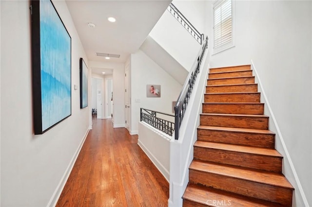 stairs featuring hardwood / wood-style floors