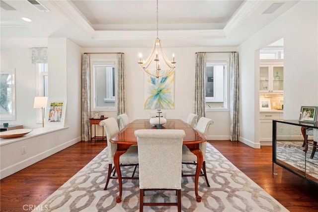 dining room with a raised ceiling, a notable chandelier, dark hardwood / wood-style flooring, and a wealth of natural light