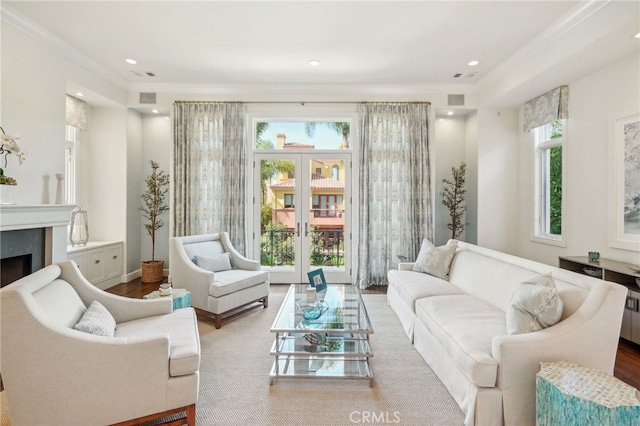 sitting room with crown molding, plenty of natural light, and a fireplace