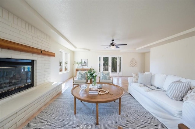 living room featuring hardwood / wood-style floors, ceiling fan, and a fireplace