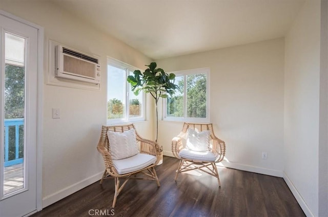 living area with an AC wall unit and dark wood-type flooring