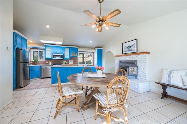 dining room featuring ceiling fan, light tile patterned floors, and vaulted ceiling