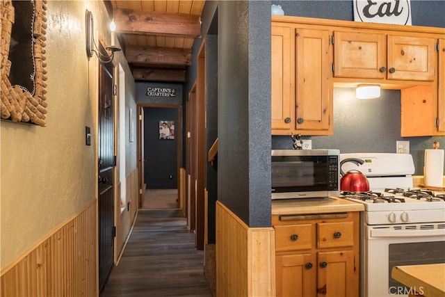 kitchen with wood ceiling, beam ceiling, wooden walls, white gas stove, and dark hardwood / wood-style flooring