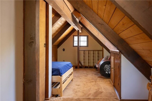 unfurnished bedroom featuring light carpet, lofted ceiling with beams, and wooden ceiling