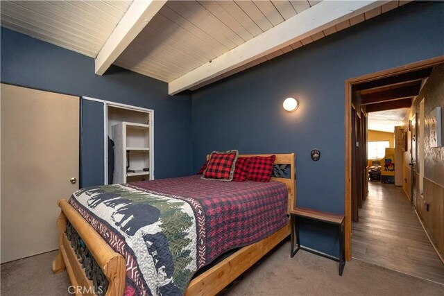 bedroom with beamed ceiling and hardwood / wood-style floors