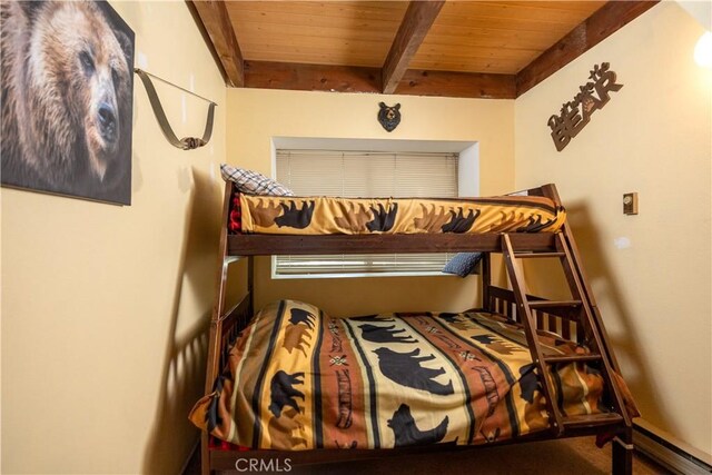 bedroom featuring a baseboard radiator, beamed ceiling, and wooden ceiling