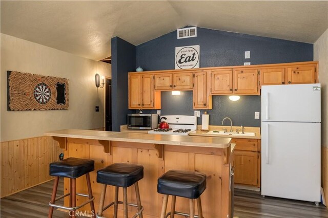 kitchen featuring vaulted ceiling, sink, dark wood-type flooring, and white appliances