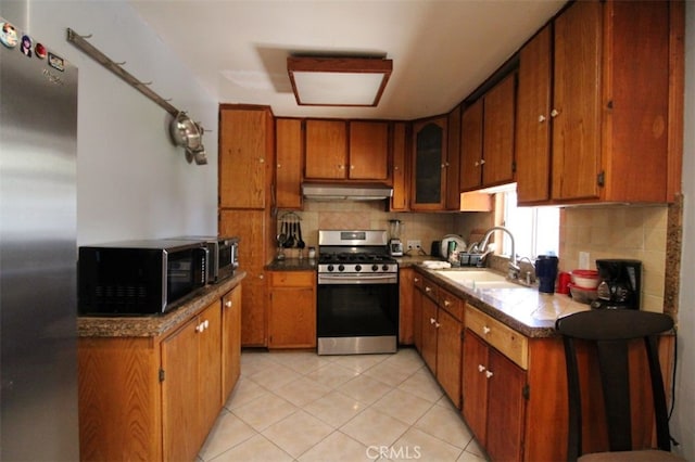 kitchen featuring light tile patterned floors, stainless steel appliances, sink, and backsplash