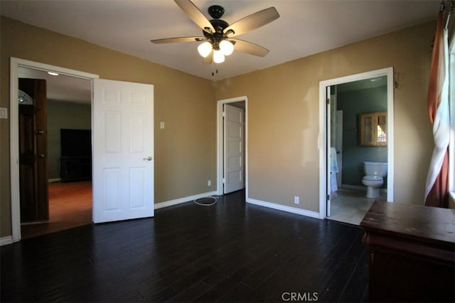 unfurnished bedroom with ensuite bath, dark wood-type flooring, and ceiling fan