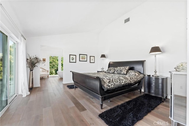 bedroom featuring hardwood / wood-style floors and high vaulted ceiling