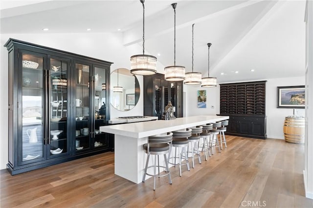 kitchen featuring pendant lighting, a center island, light hardwood / wood-style flooring, and vaulted ceiling with beams