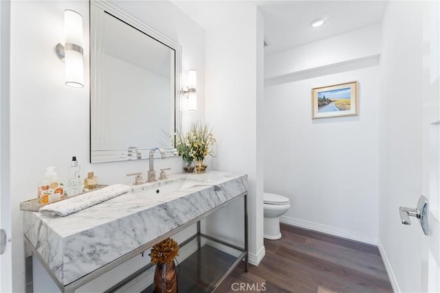 bathroom with hardwood / wood-style flooring, vanity, and toilet