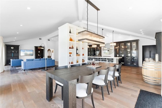 dining area with light hardwood / wood-style floors and lofted ceiling