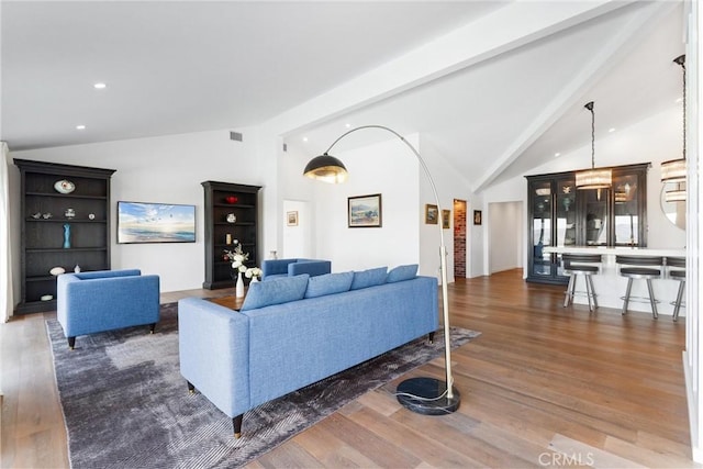 living room featuring vaulted ceiling with beams and dark wood-type flooring