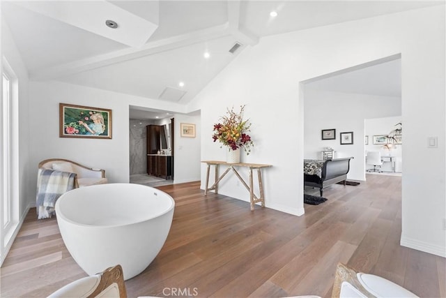 interior space with light hardwood / wood-style flooring, beamed ceiling, a healthy amount of sunlight, and high vaulted ceiling