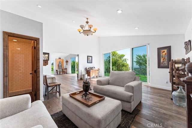 living room with dark hardwood / wood-style floors, a chandelier, and vaulted ceiling