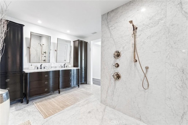 bathroom with vanity and a tile shower