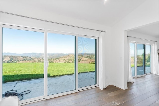 entryway featuring hardwood / wood-style flooring, a mountain view, and lofted ceiling