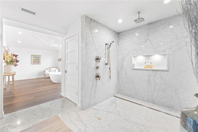 bathroom with hardwood / wood-style flooring and a tile shower