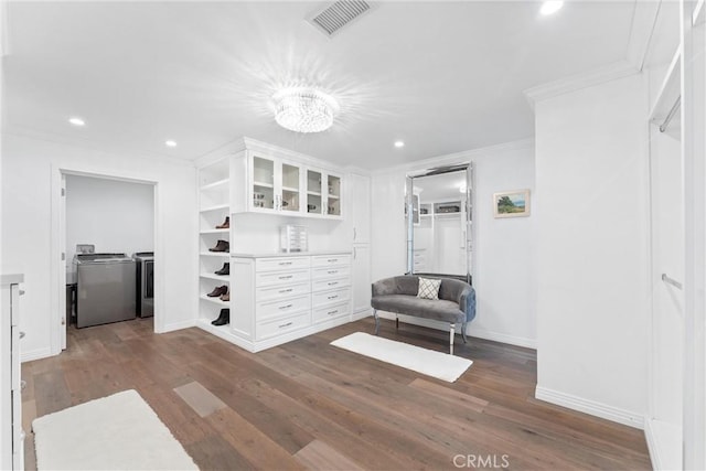 living area featuring crown molding, dark hardwood / wood-style flooring, and a notable chandelier