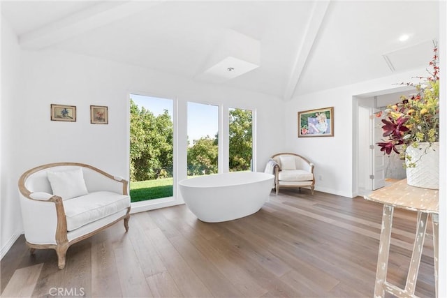 sitting room with hardwood / wood-style floors and vaulted ceiling with beams