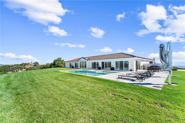 back of property with a lawn and a patio area