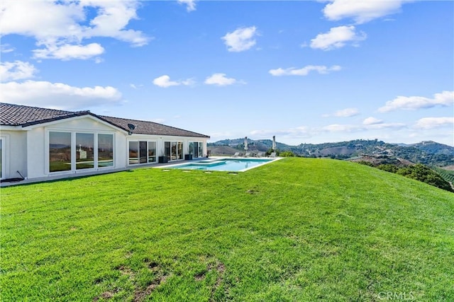 rear view of property featuring a mountain view and a yard