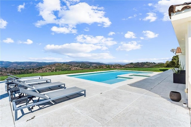 view of swimming pool featuring a mountain view and a patio