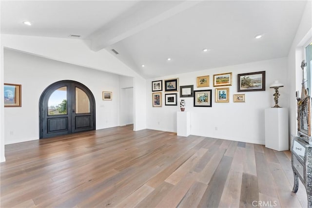 foyer entrance featuring vaulted ceiling with beams, french doors, and light hardwood / wood-style flooring