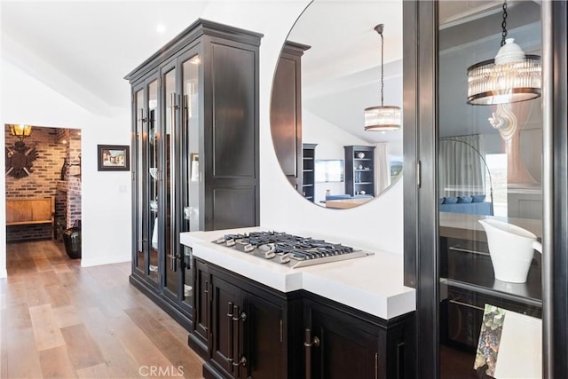 kitchen featuring light hardwood / wood-style flooring, pendant lighting, lofted ceiling, and stainless steel gas cooktop