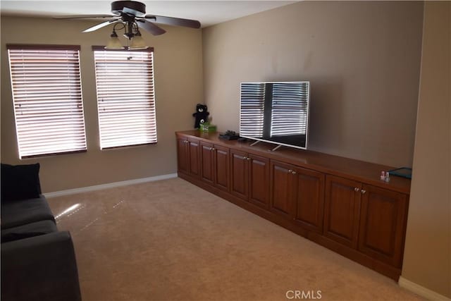 sitting room with light carpet, ceiling fan, and baseboards