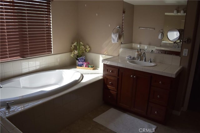 full bathroom featuring tile patterned flooring, a garden tub, and vanity