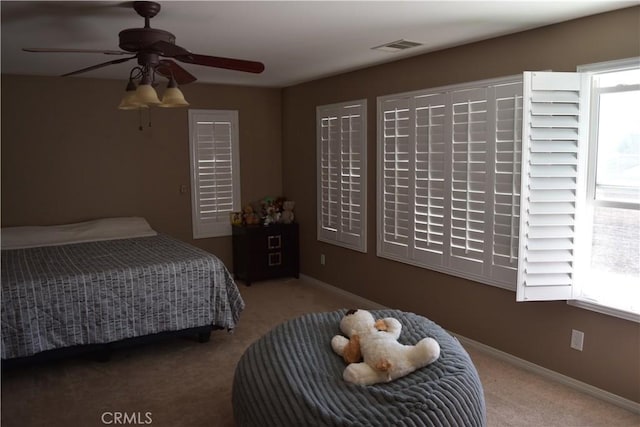 carpeted bedroom featuring multiple windows, visible vents, and baseboards