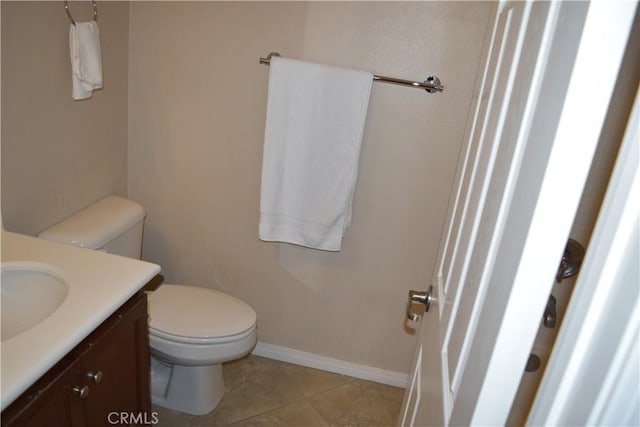 bathroom with baseboards, vanity, toilet, and tile patterned floors