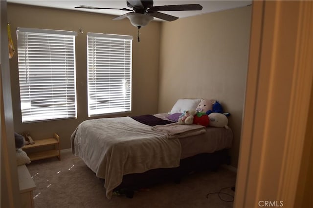 bedroom with a ceiling fan, carpet flooring, and baseboards