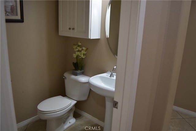 bathroom featuring toilet, tile patterned flooring, and baseboards