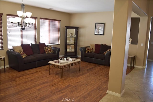 living room with a chandelier, wood finished floors, and baseboards