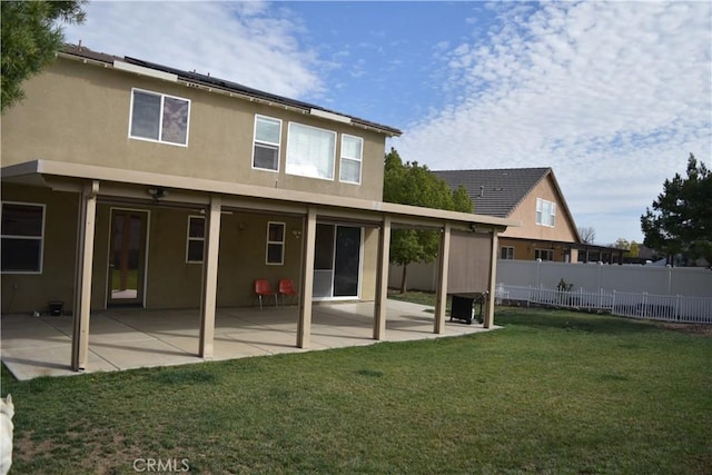 rear view of property with a yard, a patio, fence, and stucco siding