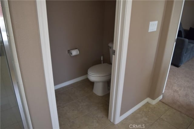 bathroom with baseboards, toilet, and tile patterned floors