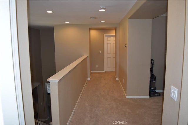 hall with recessed lighting, light colored carpet, visible vents, baseboards, and an upstairs landing